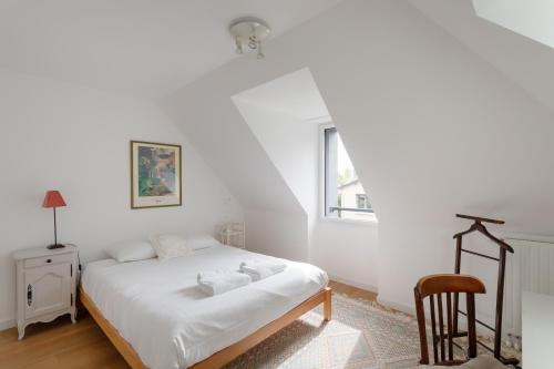 biała sypialnia z łóżkiem i krzesłem w obiekcie La Petite Enogatine - A moins d'un km de la plage w mieście Dinard