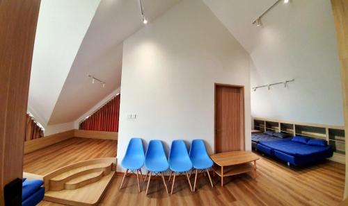 une chambre avec des chaises bleues, une table et un canapé dans l'établissement Moon Villa- Melorita Hòa Lạc, à Ðào Lãng