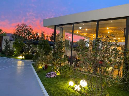 a garden in front of a building at dusk at Grand White City Hotel in Berat
