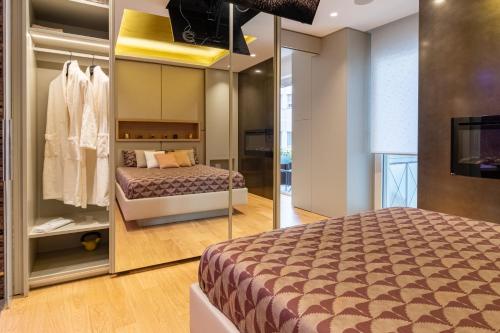 een slaapkamer met een bed en een spiegel bij Pescara Inn Luxury Suites in Pescara