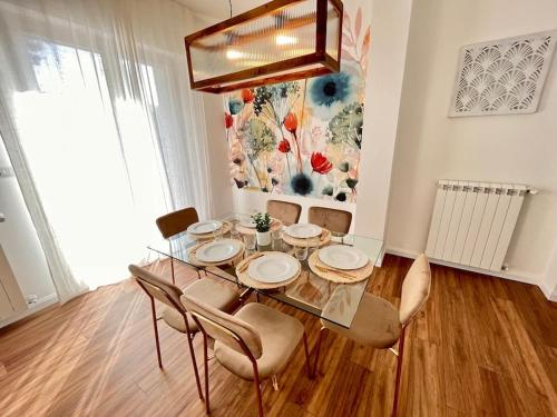 a dining room with a glass table and chairs at Civico Uno Appartamento in Torgiano