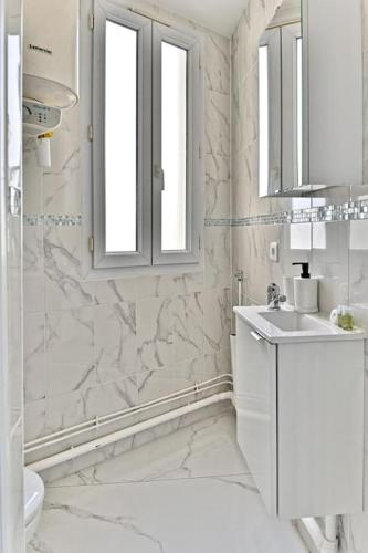 une salle de bain blanche avec un lavabo et des toilettes dans l'établissement Magnifique 2 pieces aux portes de Paris, à Gagny