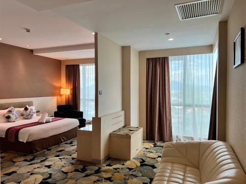 pokój hotelowy z łóżkiem i dużym oknem w obiekcie Imperial Hotel Kuching w mieście Kuching