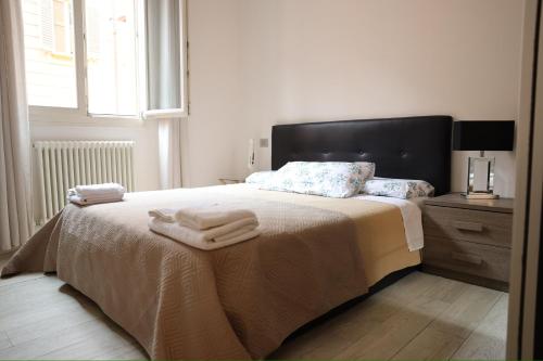 1 dormitorio con 1 cama con toallas en Appartamento Righi24, en Bolonia