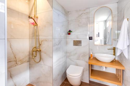 uma casa de banho com um chuveiro, um WC e um lavatório. em Villa Envy by Villa Plus em Malia