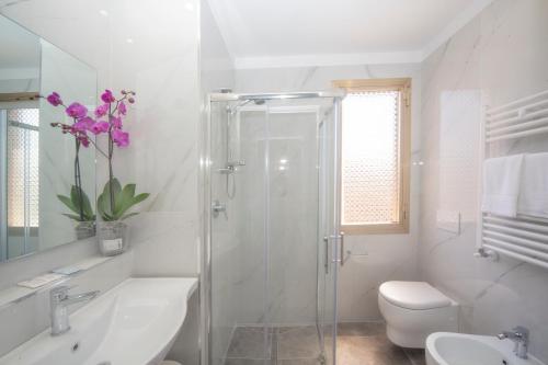 a bathroom with a shower and a toilet and a sink at Hotel Marselli in Rimini