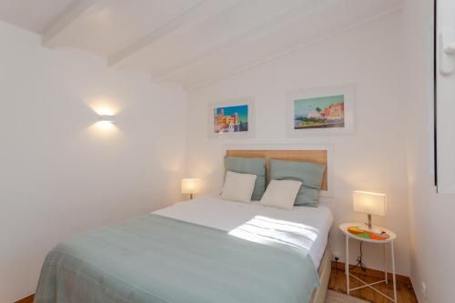 1 dormitorio blanco con 1 cama grande y 2 lámparas en Palace Guest Inn, en Queluz