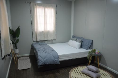 um pequeno quarto com uma cama e uma janela em The Vanilla Cabin 