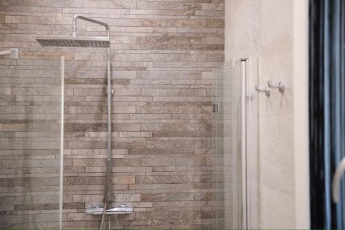 y baño con ducha y pared de ladrillo. en Appartamento Righi24 en Bolonia