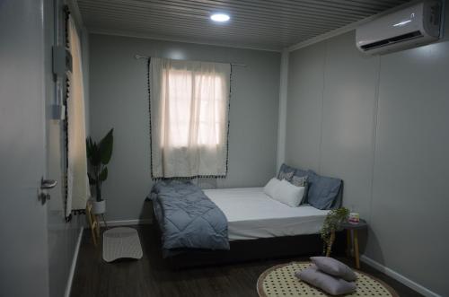 a small bedroom with a bed and a window at The Vanilla Cabin 1 in Kampung Tok Jembal