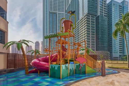 a playground with a water slide in front of a city at Four Points by Sheraton Kuala Lumpur, City Centre in Kuala Lumpur