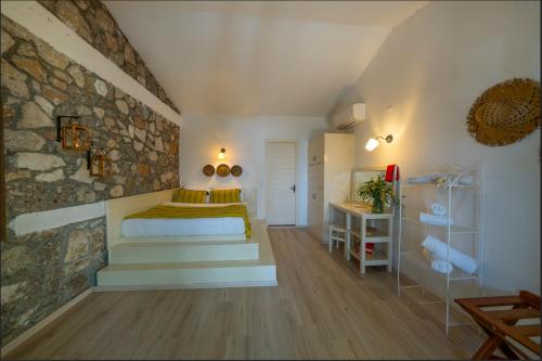 a bedroom with a bed and a stone wall at Nautical Hotel in Faralya