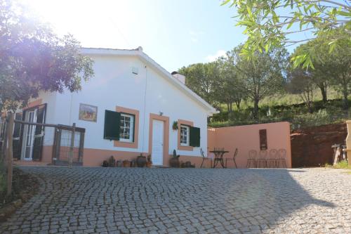 a white house with a cobblestone driveway at Maison Algarve in Mexilhoeira Grande