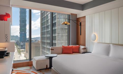 a hotel room with a bed and a large window at W Taipei in Taipei