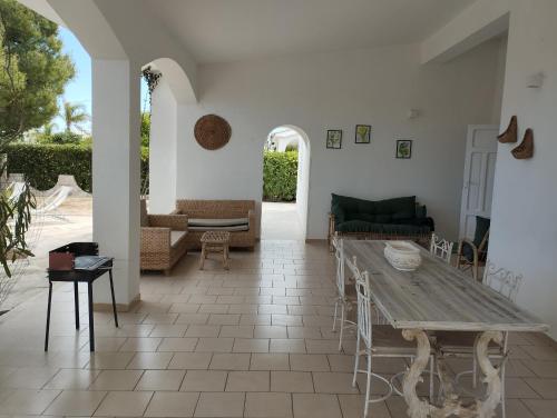 ein Wohnzimmer mit einem Holztisch und Stühlen in der Unterkunft Villa Maria in Villanova di Ostuni