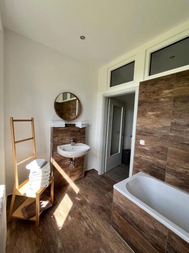 a bathroom with a tub and a sink and a mirror at Landgasthof & Hotel Waldeck in Treuen