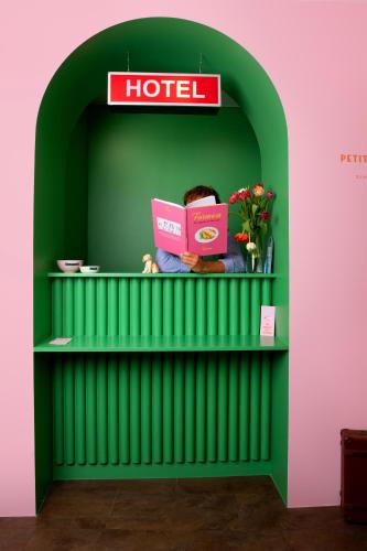 a person sitting on a shelf with a laptop at DEMAIN Hôtel in Nantes