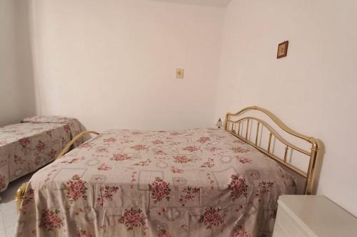 een slaapkamer met 2 bedden met een bloemenbed bij La Casa dei Nonni in Certaldo