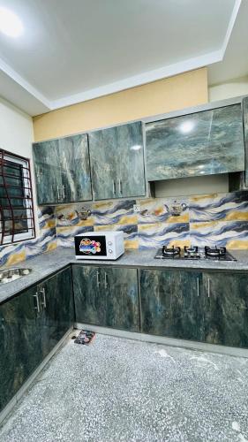 - une cuisine avec un comptoir et un four micro-ondes dans l'établissement Rahat Arcade, à Islamabad