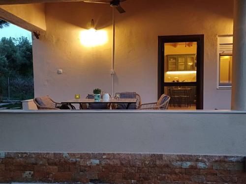 a patio with chairs and a table with a light at Berry House Nikiti in Skála Nikíta