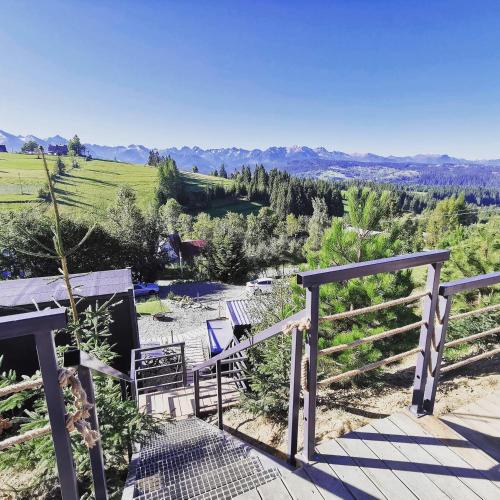 a deck with chairs and a view of the mountains at Rzepiska Hills in Rzepiska