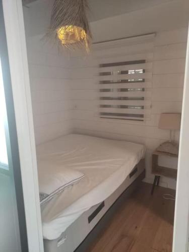 une petite chambre avec un lit dans une pièce dans l'établissement Joli T2 bas de chalet plage de Gruissan, à Gruissan