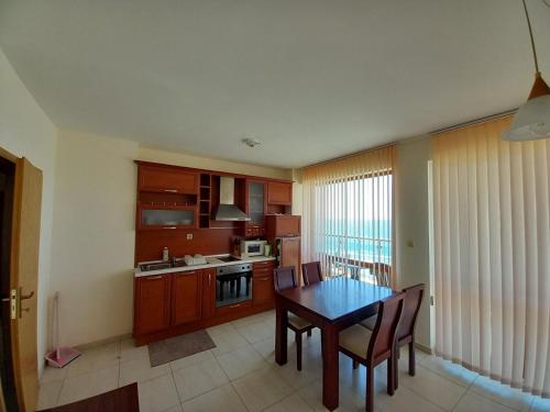 a kitchen with a table and chairs in a room at Апартаменти СЪНИ БЕЙ in Sunny Beach
