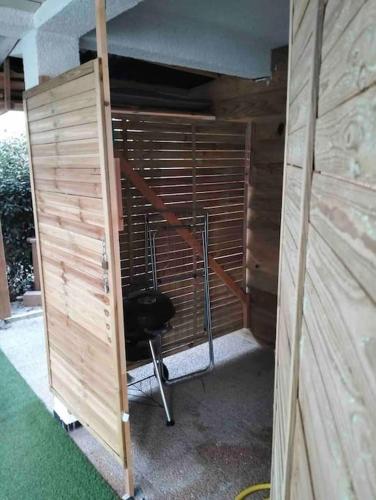 Cette chambre est dotée d'un mur en bois et d'une chaise. dans l'établissement Joli T2 bas de chalet plage de Gruissan, à Gruissan