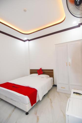 a white bedroom with a bed with a red blanket at Hà Thành Hotel in Phan Thiet