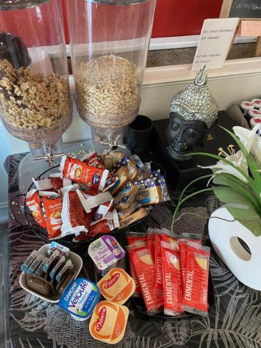 a table topped with different types of snacks and a bust at Hôtel Le Home Saint Louis in Versailles