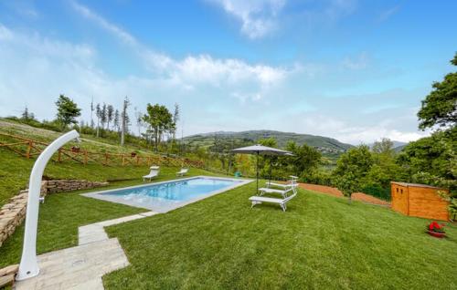 a backyard with a swimming pool and an umbrella at Antico Casale di Ferdinandi in Bibbiena