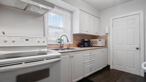 a kitchen with white cabinets and a sink at Niagara Falls home in Niagara Falls