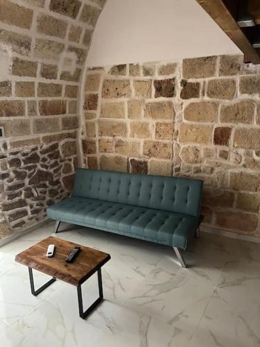 a green couch sitting in a room with a coffee table at La botte in Mesagne