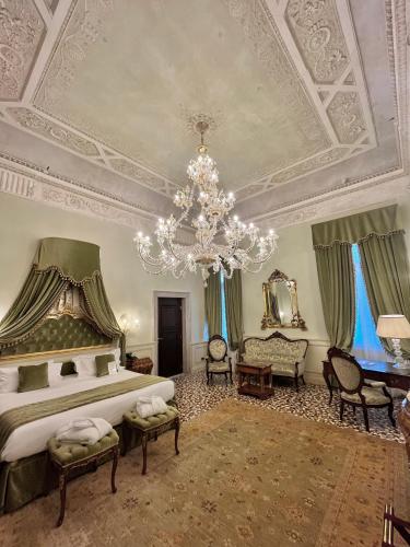 a large bedroom with a bed and a chandelier at Hotel Nani Mocenigo Palace in Venice