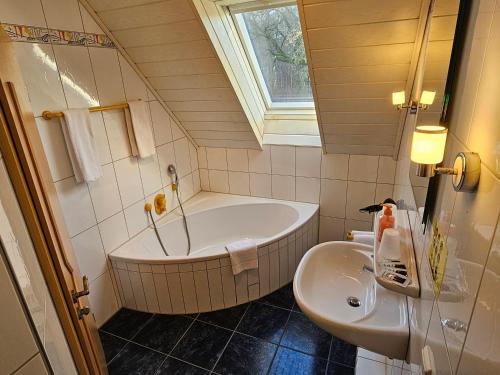 a bathroom with a tub and a sink at Gästehaus Grunewald Bed & Breakfast in Heiden