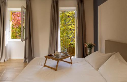 Residence Casa Coppa Appartamento Maple في أومغنا: غرفة نوم مع سرير أبيض مع طاولة عليها
