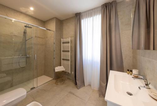 La salle de bains est pourvue d'une douche et d'un lavabo. dans l'établissement Residence Casa Coppa Appartamento Maple, à Omegna