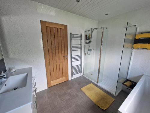 a bathroom with a shower and a wooden door at Royal Troon Open 2024 in Kilwinning