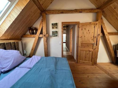 um quarto com uma cama azul num sótão em Gästewohnung auf dem Heilandhof 