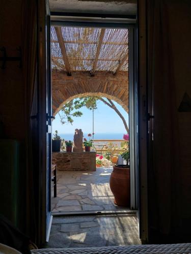 an open door to a patio with a view of the ocean at Villa Art Natalie two in Kithnos