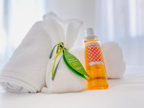 une bouteille de liquide orange à côté d'une serviette dans l'établissement Le Boëste - Magnifique logement lumineux, à Cannes