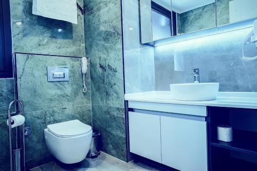 伊斯坦堡的住宿－ONKA OTELCİLİK TURİZM TİCARET LİMİTED ŞİRKETi，浴室配有白色卫生间和盥洗盆。