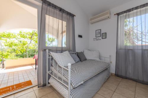 a room with a bed and a large window at Charming holiday home Little House in Povljana