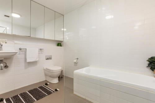 y baño con bañera, aseo y lavamanos. en Stylish 2-Bed Unit with Garden Patio and Balcony, en Sídney