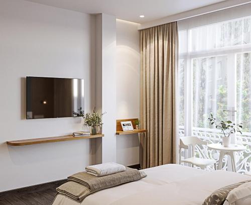 a bedroom with a bed and a large window at LANGHAM Boutiqu Hotel in Ho Chi Minh City