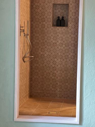 a shower in a bathroom with a tiled wall at GarganoMareBorghi ospitalità diffusa in Vico del Gargano