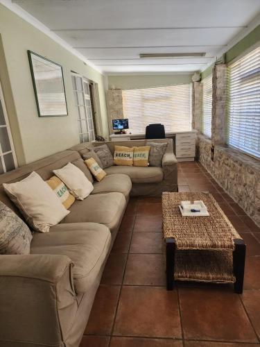 a living room with a couch and a table at 16 on Main Arniston PET-FRIENDLY in Arniston