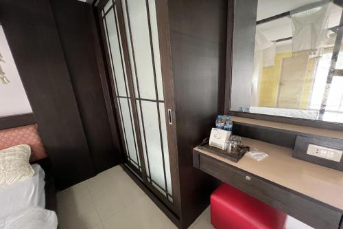 Una pequeña habitación con un escritorio y una ventana. en Phongsathon Mansion, en Bangkok