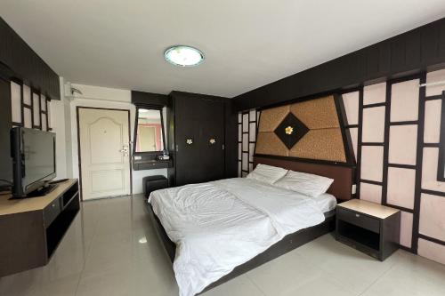 Un dormitorio con una cama grande y un televisor. en Phongsathon Mansion, en Bangkok