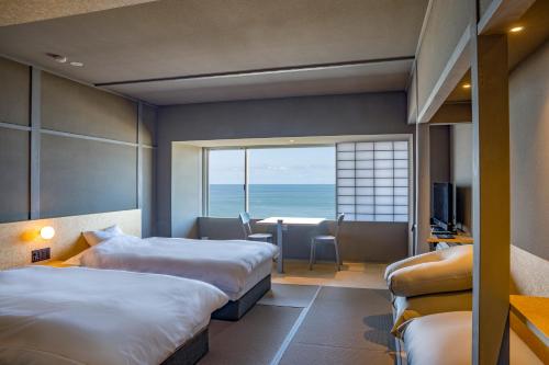 a hotel room with two beds and a view of the ocean at Kameya Hotel in Tsuruoka
